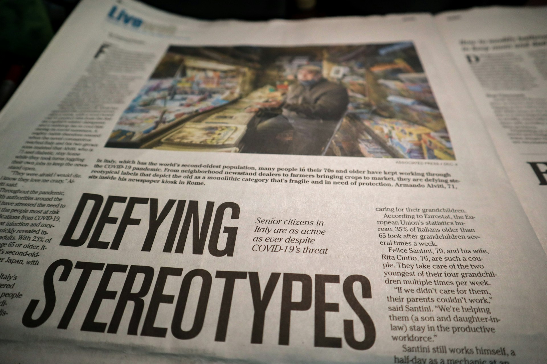 A newspaper page featuring an article titled “Defying Stereotypes,” with an image of a senior citizen working in a kiosk, symbolizing breaking societal biases.